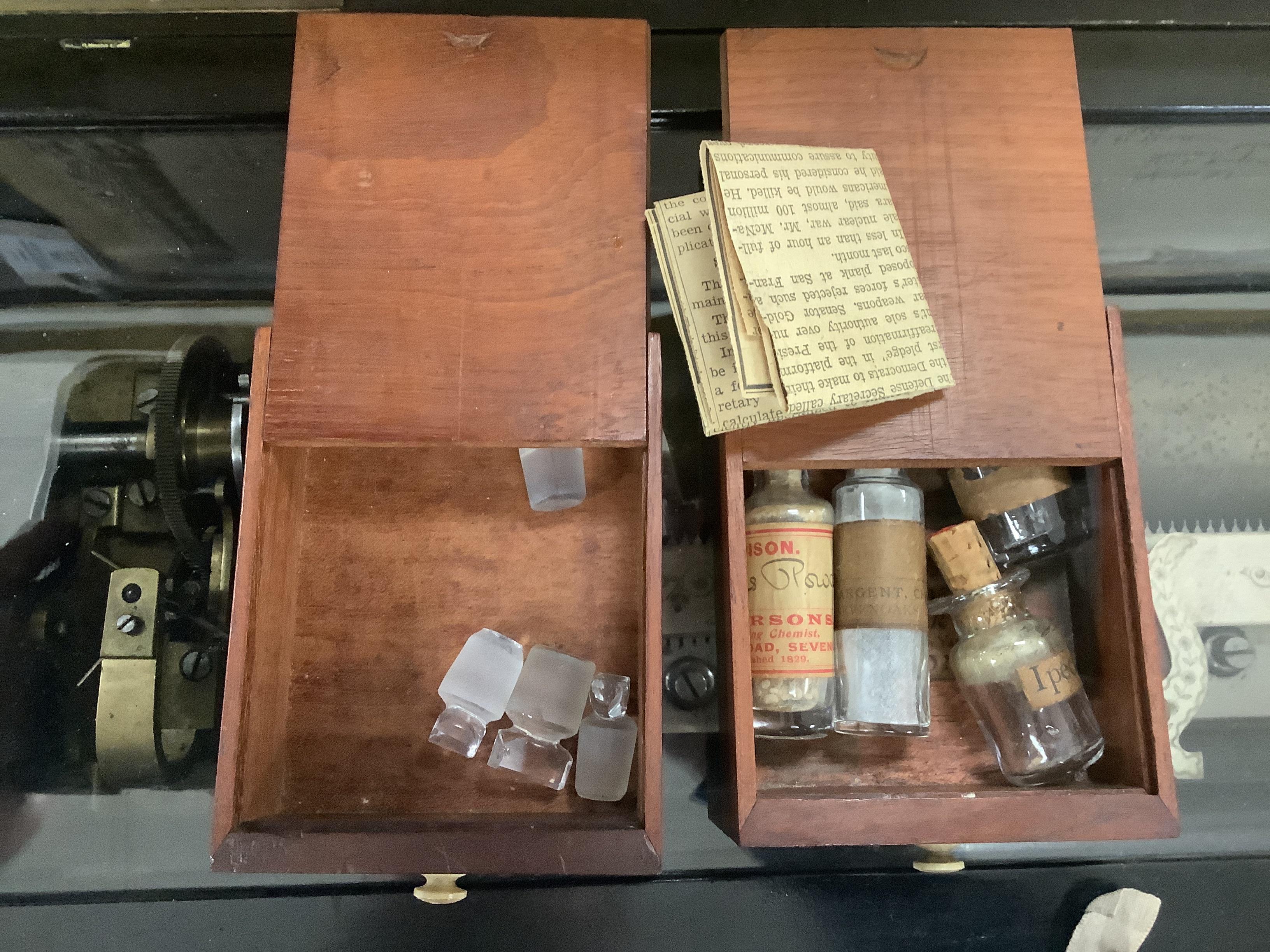 A Georgian mahogany domestic medicine chest, with bone drawer knobs and escutcheons, containing a number of glass square section drug bottles, fitted drawers containing scales, a pestle and mortar, etc., 29cm wide, 25cm